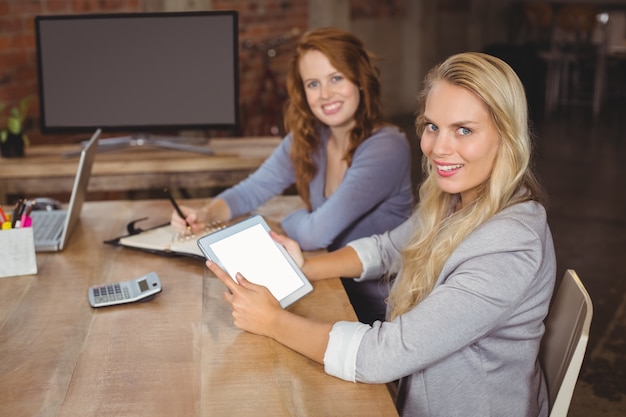 A woman is meeting with a financial advisor in a modern office setting. They are looking at charts and graphs on a tablet, and the advisor is explaining different investment strategies. The scene conveys trust and expert guidance.
