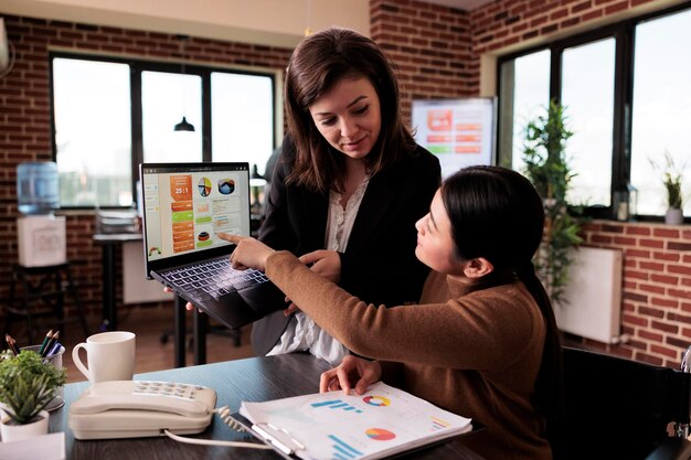 A teacher smiling while using an AI-powered dashboard. The dashboard displays real-time analytics on student performance, attendance, and engagement metrics. The teacher is using the data to identify students who need extra support.