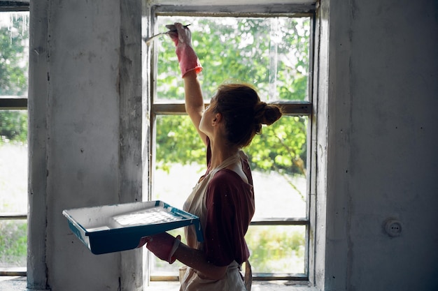 A person sealing windows with weather stripping to improve energy efficiency.