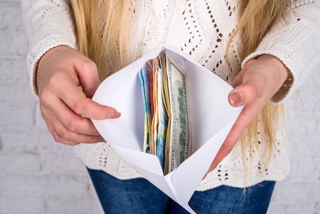 A close-up shot of a person's hands carefully counting cash while organizing envelopes labeled with various budget categories, such as 