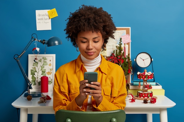 A person browsing social media on their phone, with ads for various products and services popping up, symbolizing the influence of social media on spending habits.