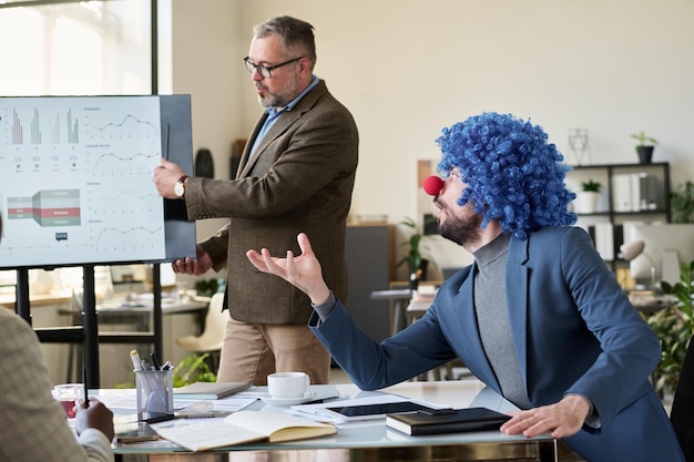 Two colleagues discussing performance metrics and compensation details during a performance review meeting in a modern office setting.