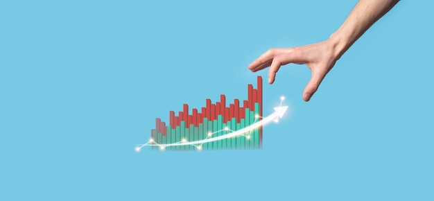 A close-up of a hand holding a miniature house with stock market charts displayed in the background, symbolizing investing in company stock through an ESPP.