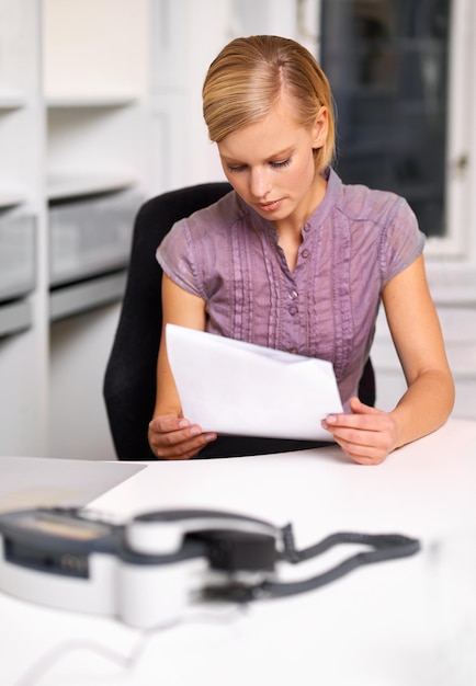 A person sitting at a desk, reviewing documents related to employee benefits, with a calculator and a cup of coffee nearby, illustrating the careful consideration required when choosing voluntary benefits.