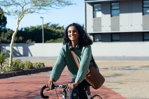 A young professional happily riding a bicycle to commute to work, showing the positive impact of voluntary wellness benefits on an individual's lifestyle and well-being.