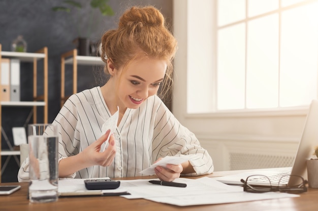 A person reviewing and comparing different insurance policy documents at a desk, with a calculator and pen nearby.
