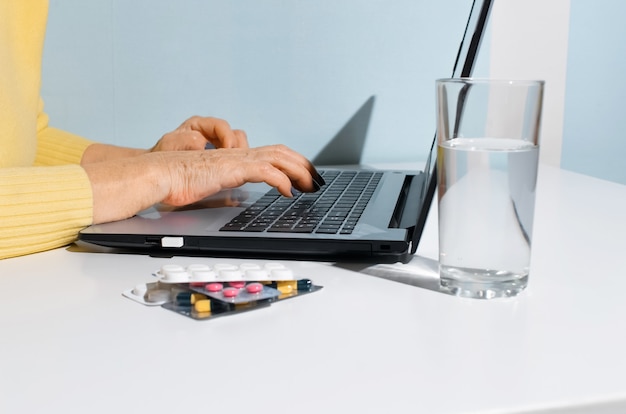 A person sitting at a desk, reviewing documents related to health insurance options, including a COBRA election form. They are using a laptop to research alternatives online.