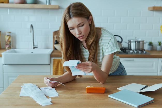 A person carefully organizing medical bills, receipts, and insurance forms on a desk. The scene emphasizes attention to detail, methodical arrangement, and the importance of keeping documents in order when preparing a claim.